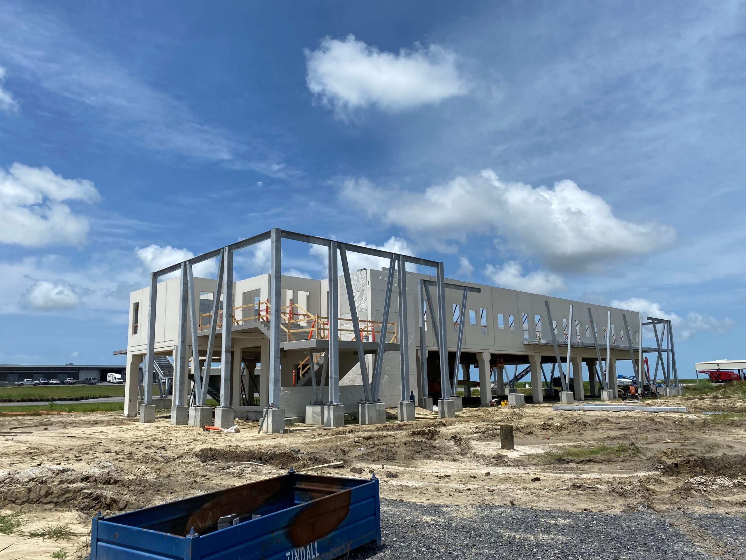 in progress precast concrete structure located next to a body of water in a marsh